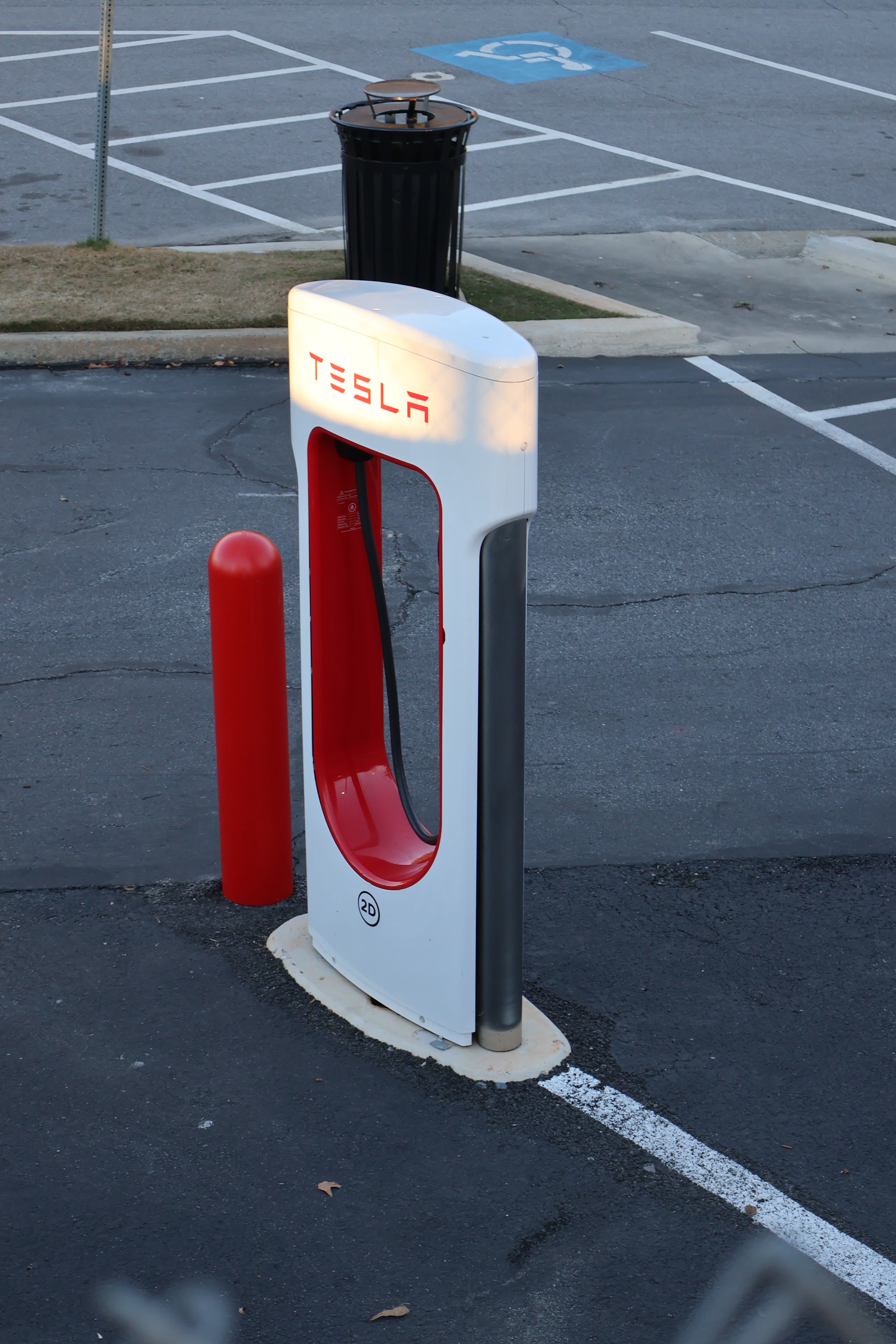 Rows of Tesla Supercharger stalls (V3) in a parking lot