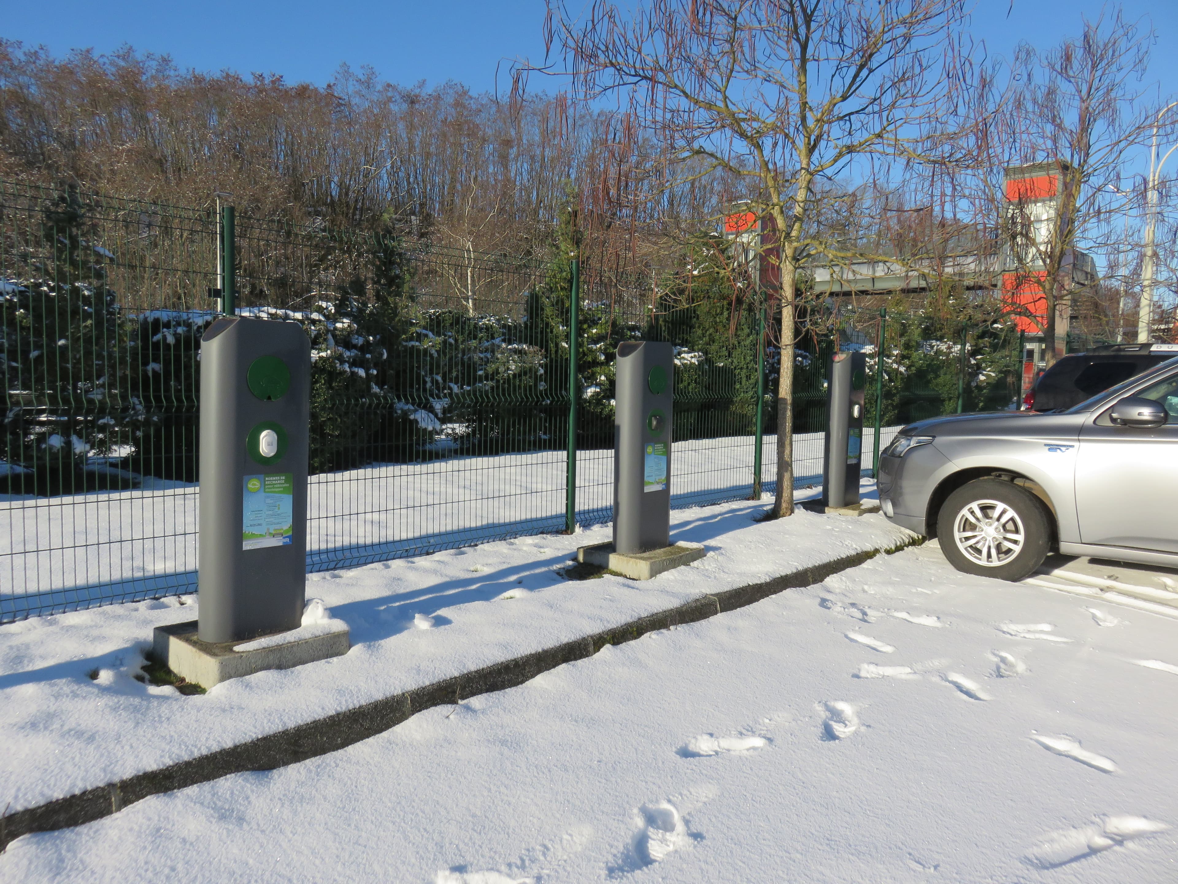AC chargers covered in snow by a train station
